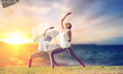 Image of couple making yoga warrior pose outdoors