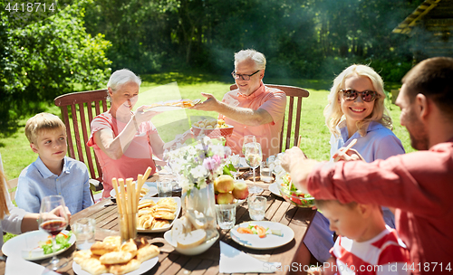 Image of happy family having dinner or summer garden party