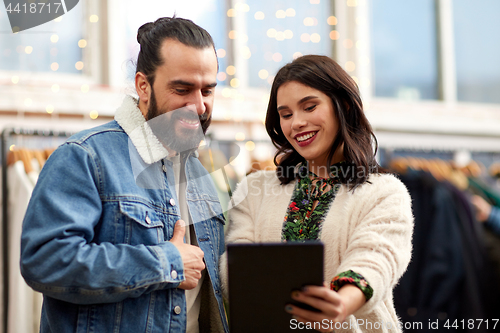 Image of couple with tablet pc at vintage clothing store