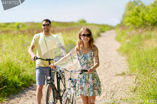 Image of happy couple with bicycles on country road