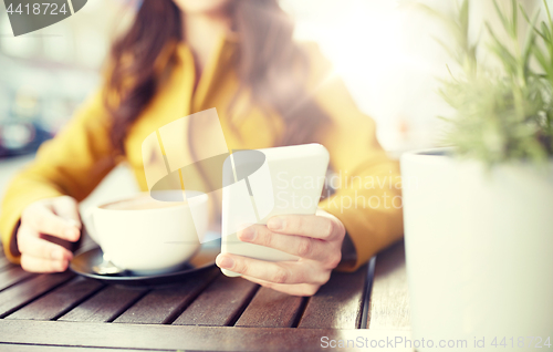 Image of close up of woman texting on smartphone at cafe