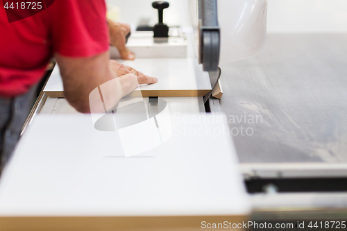 Image of carpenter with panel saw and fibreboard at factory