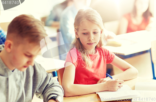 Image of group of students with books writing school test