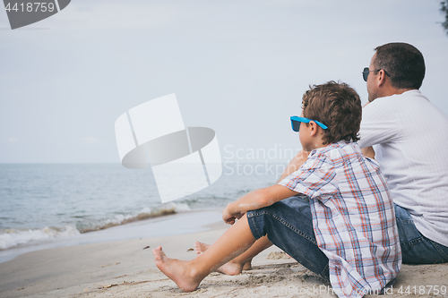 Image of Portrait of young sad little boy and father sitting outdoors at 