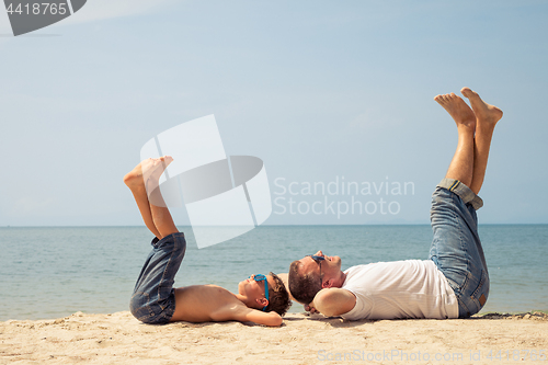 Image of Father and son playing on the beach at the day time.