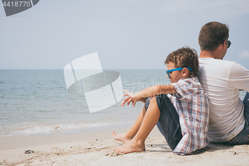 Image of Portrait of young sad little boy and father sitting outdoors at 