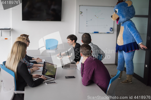 Image of boss dresed as bear having fun with business people in trendy of