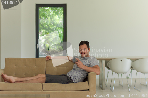 Image of young man using a mobile phone  at home