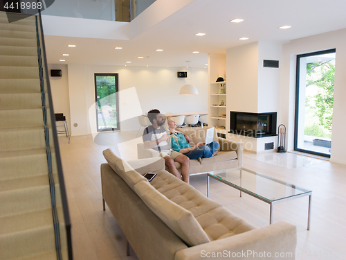 Image of young happy couple relaxes in the living room