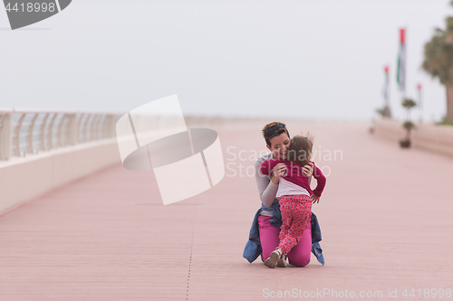 Image of mother and cute little girl on the promenade by the sea