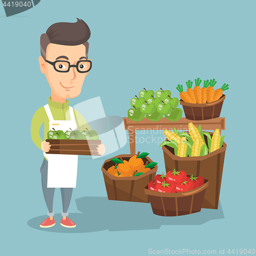 Image of Supermarket worker with a box full of apples.