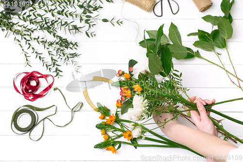 Image of Female florist making beautiful bouquet at flower shop