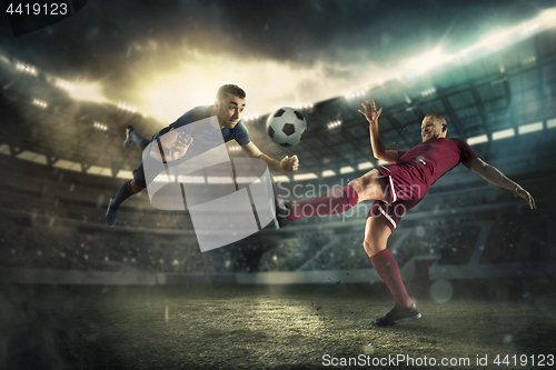 Image of The football player in motion on the field of stadium