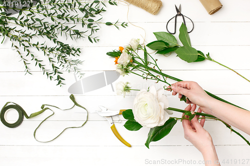 Image of Female florist making beautiful bouquet at flower shop