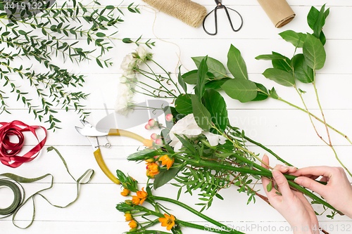 Image of Female florist making beautiful bouquet at flower shop