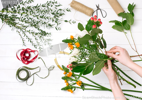 Image of Female florist making beautiful bouquet at flower shop