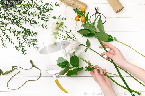 Image of Female florist making beautiful bouquet at flower shop