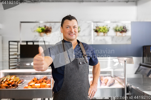 Image of seafood seller at fish shop showing thumbs up