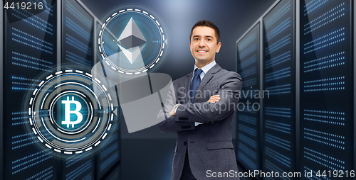 Image of businessman with cryptocurrency holograms