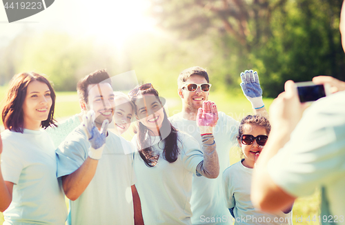 Image of group of volunteers taking picture by smartphone