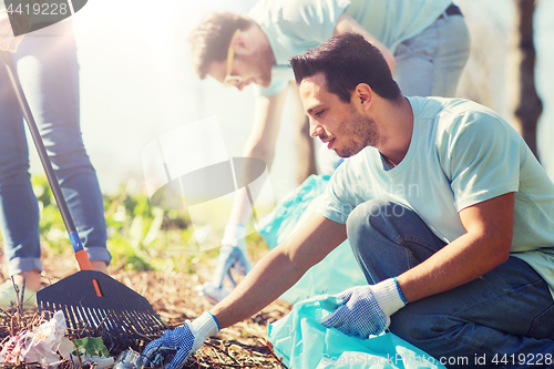 Image of volunteers with garbage bags cleaning park area