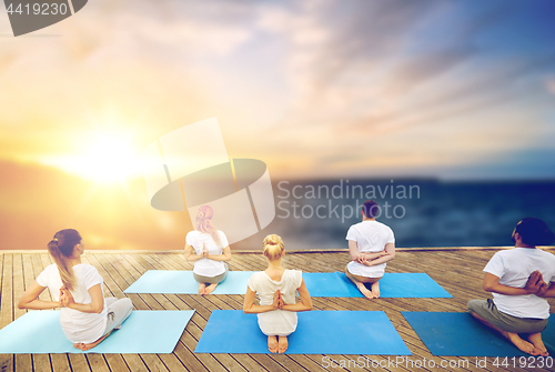 Image of group of people doing yoga outdoors