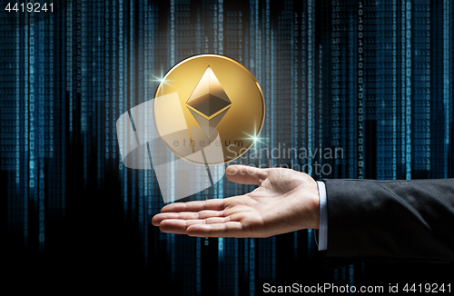 Image of businessman hand with etherum over binary code