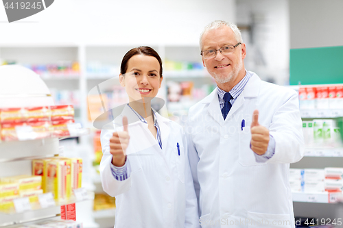 Image of happy apothecaries showing thumbs up at pharmacy