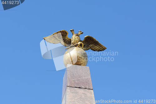 Image of Golden two-headed eagle sculpture on obelisk