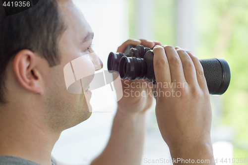 Image of man looking with binoculars