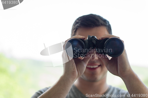 Image of man looking with binoculars