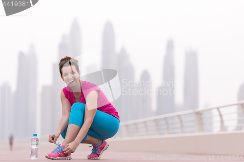 Image of woman tying shoelaces on sneakers