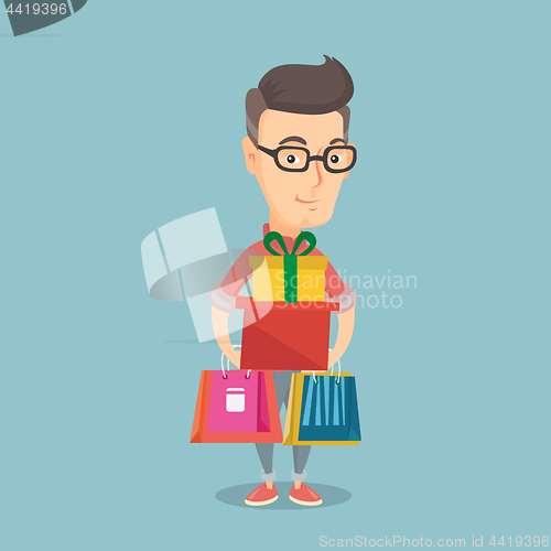 Image of Happy man holding shopping bags and gift boxes.