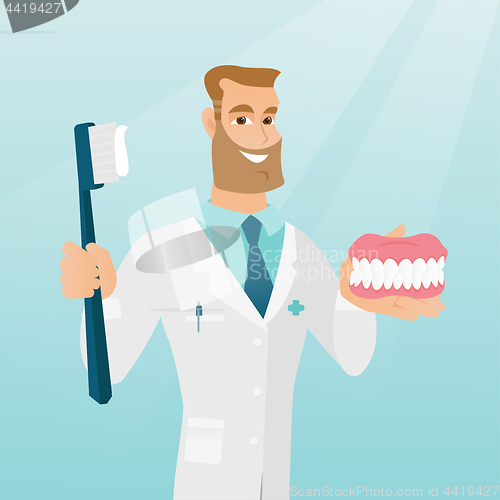 Image of Dentist with a dental jaw model and a toothbrush.