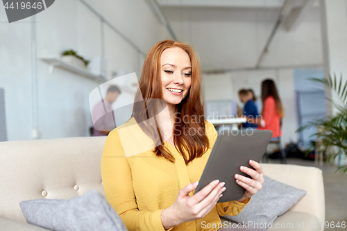 Image of redhead woman with tablet pc working at office