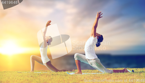 Image of couple making yoga low lunge pose outdoors