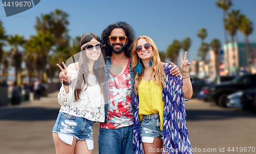 Image of hippie friends showing peace at venice beach in la