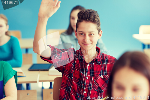 Image of happy student boy raising hand at school lesson