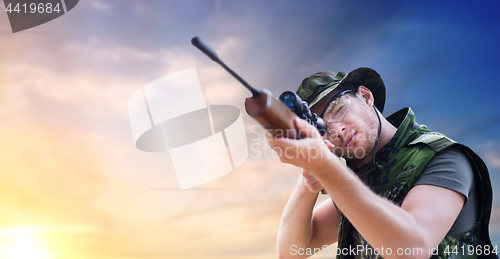 Image of soldier or hunter with gun aiming or shooting