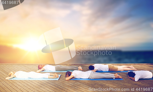 Image of group of people doing yoga outdoors