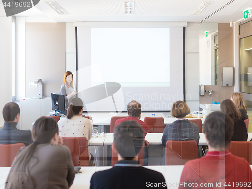 Image of Woman giving presentation in lecture hall at university.