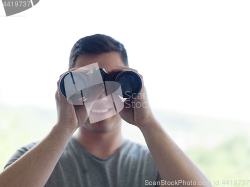 Image of man looking with binoculars