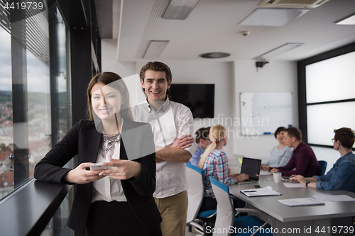 Image of Elegant Woman Using Mobile Phone by window in office building