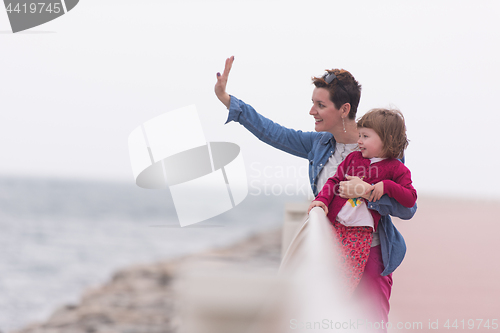 Image of mother and cute little girl on the promenade by the sea