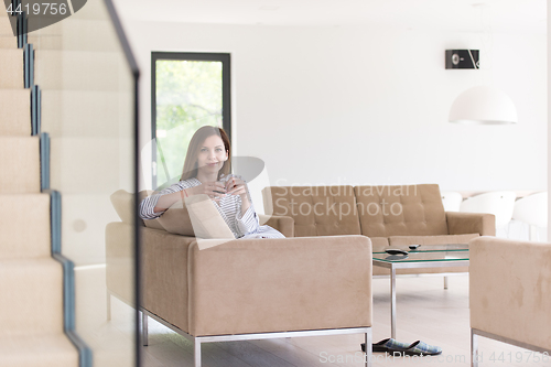 Image of young woman in a bathrobe enjoying morning coffee