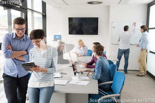 Image of Two Business People Working With Tablet in office