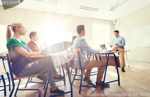 Image of group of students and teacher with papers or tests