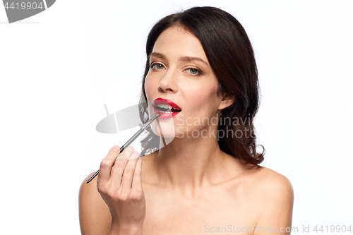 Image of beautiful woman with make up brush for lipstick