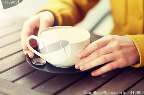 Image of close up of woman with cocoa cup at street cafe