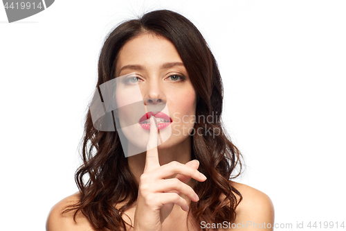 Image of woman with red lipstick holding finger on mouth